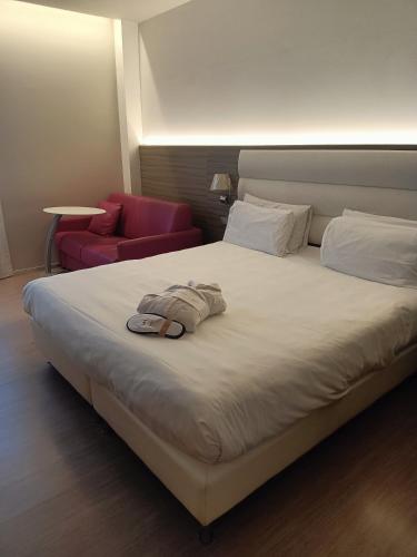 a hotel room with a bed and a red chair at Hotel Mercure Venezia-Marghera in Marghera