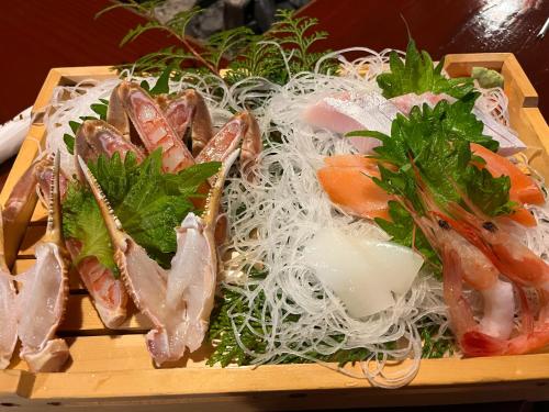a wooden tray of food with noodles and shrimp at Pension Kurumi no Ki in Toyooka