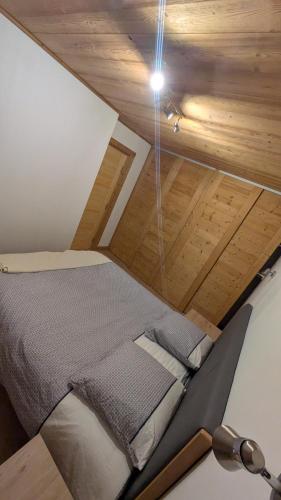 un lit dans une chambre avec un plafond en bois dans l'établissement L'Helvetia, à Chamonix-Mont-Blanc