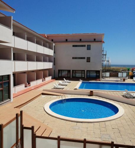 a building with a swimming pool in front of a building at Hotel Santo Andre in Póvoa de Varzim