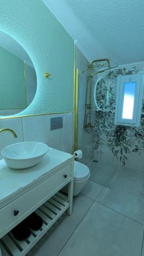 a bathroom with a sink and a toilet and a mirror at Rabando Suit in Uzungol