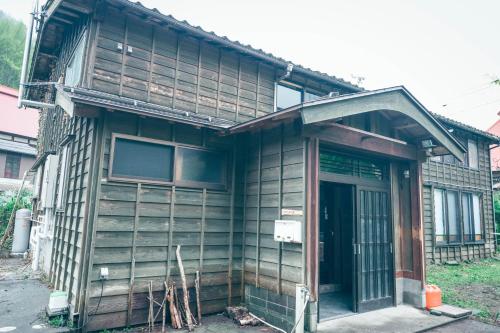 an old house with a porch and a door at ツギハギの家 in Itoigawa