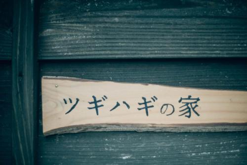 a sign on a wall with asian writing on it at ツギハギの家 in Itoigawa