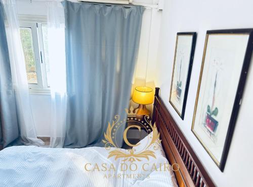a bedroom with a bed with blue curtains and a lamp at Casa Do Cairo-Sharm Alsheikh in Sharm El Sheikh