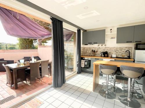 une cuisine et une salle à manger avec une table et des chaises dans l'établissement Appart RDC - 4pers - Clim - Piscine, à Fitou