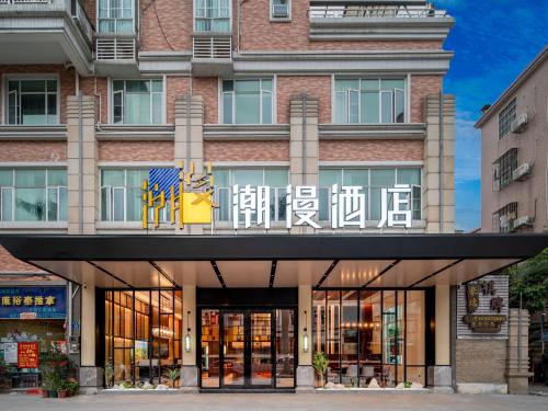 a building with a sign on the front of it at Trendy Romantic Hotel Guangzhou Panyu Qiaonan Aoyuan Plaza Branch - Free Deliver Service to Canton Fair Complex During Canton Fair Period & Free Deliver Service to Guangzhou Baiyun International Airport in Guangzhou