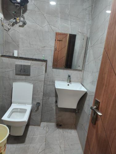 a bathroom with a white toilet and a sink at Hotel Nova Inn Near Delhi Airport in New Delhi