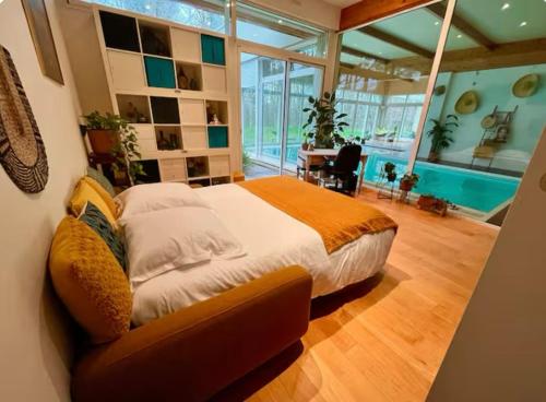 a bedroom with a large bed and a pool at Villa Verde - piscine intérieure proche Zoo de Beauval et Châteaux de la Loire in Gièvres