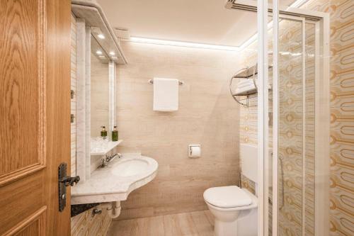 a small bathroom with a sink and a toilet at Hotel Cavallino D'Oro Bed&Breakfast in Castelrotto