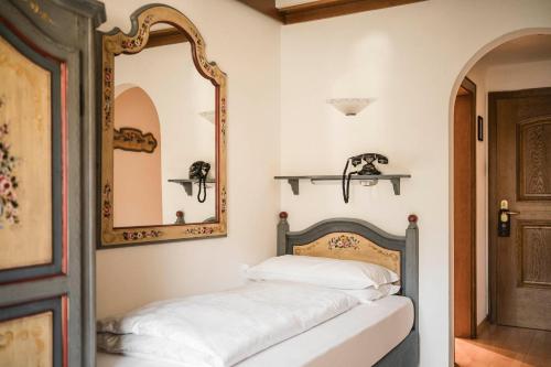 a bedroom with a mirror and a bed at Hotel Cavallino D'Oro Bed&Breakfast in Castelrotto