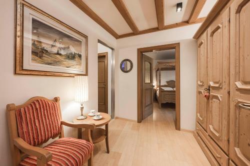 a living room with a chair and a table at Hotel Cavallino D'Oro Bed&Breakfast in Castelrotto
