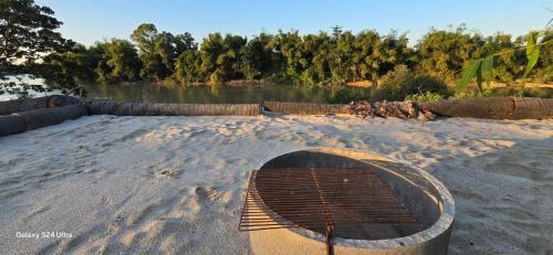 un barco sentado en la arena cerca de un cuerpo de agua en Riverland Camp, en Phumĭ Chheutéal (2)