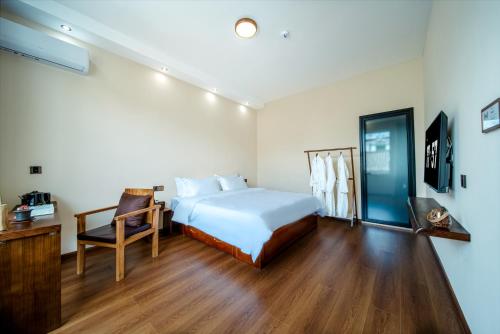 a bedroom with a bed and a desk and a chair at The Whisperer Guanshan Private Residence Hotel in Dali