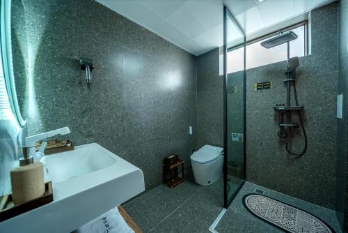 a bathroom with a sink and a shower and a toilet at The Whisperer Guanshan Private Residence Hotel in Dali