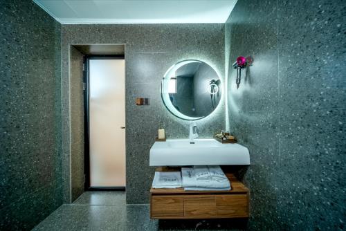 a bathroom with a sink and a mirror at The Whisperer Guanshan Private Residence Hotel in Dali