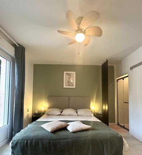 - une chambre avec un ventilateur de plafond et un lit avec deux oreillers dans l'établissement Demeure de l'Estuaire, à Plassac