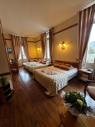 une chambre d'hôtel avec deux lits et un canapé dans l'établissement Grand Hôtel de France, à Pierrefitte-Nestalas