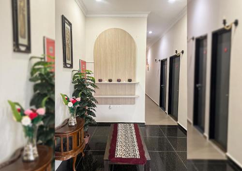two pictures of a hallway with plants and a hallway with doors at ALAN TRANSIT MOTEL - Klia in Sepang