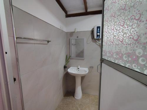 a white bathroom with a sink and a mirror at Bungalow Resort - Sigiriya in Sigiriya