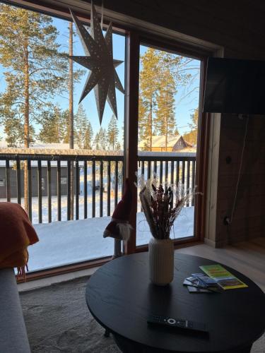 a living room with a table and a large window at Idre himmelfjäll ski in out in Idrefjäll