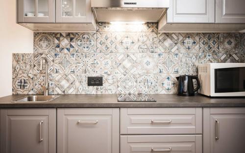 a kitchen with a sink and a microwave at Hotel Cavallino D'Oro Bed&Breakfast in Castelrotto