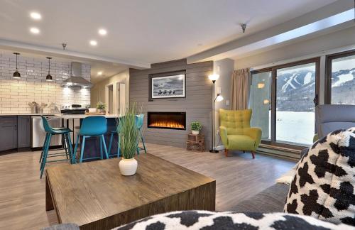 a kitchen and a living room with a fireplace at Mountain Green 3C16 - Renovated 2BR-2BA With Mountain Views, Hot Tub, Pool, Shuttle, Gym in Killington