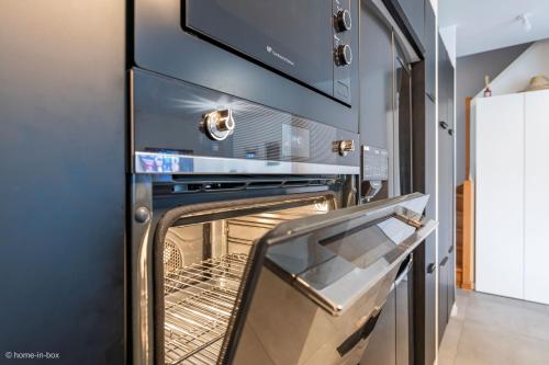 un four avec sa porte ouverte dans une cuisine dans l'établissement Maison Design 2 CH proche CDG, Paris, à Tremblay-en-France