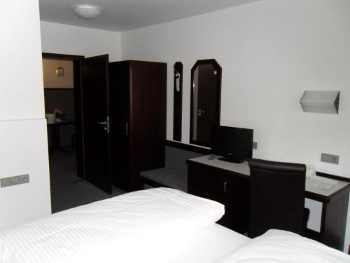 a bedroom with a bed and a desk with a computer at Hotel Gasthof Traube in Kernen