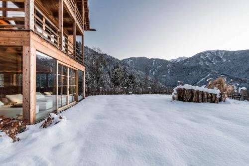 a snow covered roof of a house with mountains in the background at Naturhotel Lüsnerhof in Luson