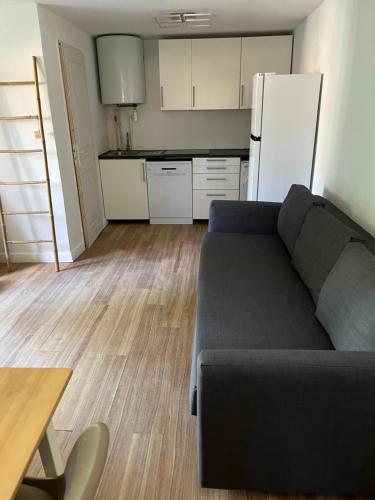 un salon avec un canapé et une cuisine dans l'établissement La mer avec un petit jardin, à Villers-sur-Mer