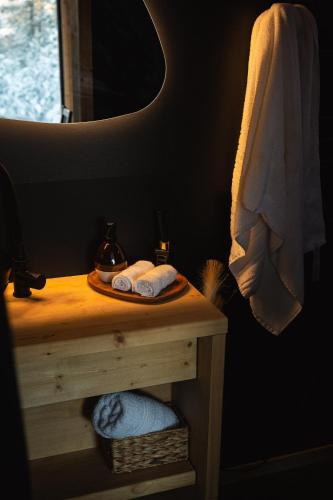 a bathroom with a table with towels and a mirror at Forestic Lietuva in Vilionys