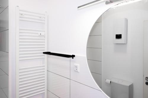 baño con espejo y paredes blancas en Cozy Apartment Wuppertal, en Wuppertal