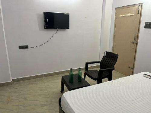 a room with a bed and a chair and a television at Rest N' Refresh Homes in Visakhapatnam