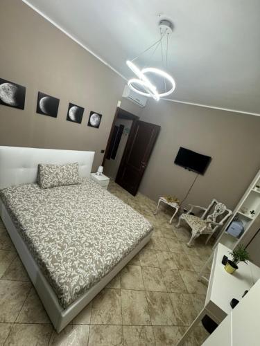 a bedroom with a bed and a chandelier at Luce - Pantano metro C in Osteria dellʼ Osa