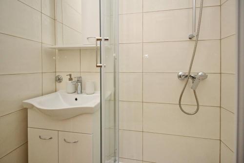 un baño con ducha y lavabo en Apartments Karamarko, en Baška