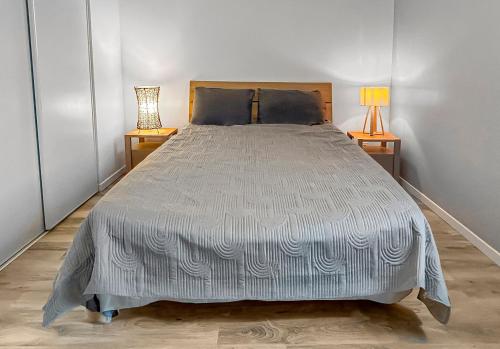 a large bed in a room with two lamps at Maison lumineuse, terrasse, à 10 min des plages in Saint-Père-en-Retz