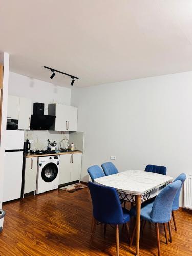 a dining room with a table and chairs and a kitchen at Hillstory Borjomi tba in Tsemi