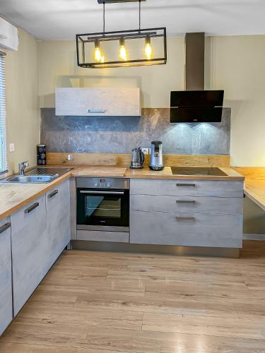 a kitchen with a sink and a stove top oven at Maison lumineuse, terrasse, à 10 min des plages in Saint-Père-en-Retz