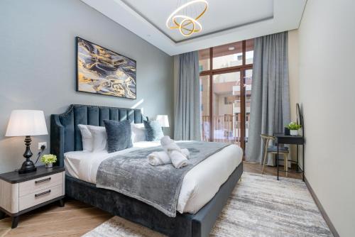 a bedroom with a bed with a teddy bear on it at White Sage New Large 1BR at JVC in Dubai