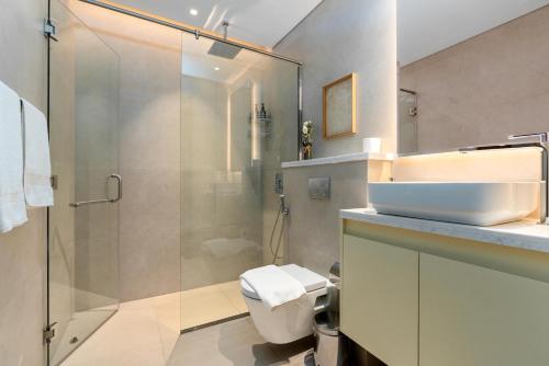 a bathroom with a shower and a toilet and a sink at White Sage New Large 1BR at JVC in Dubai