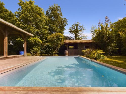 - une piscine dans un jardin avec une terrasse en bois dans l'établissement Piscine et sérénité pour votre séjour à Lanton, à Lanton