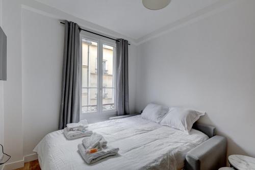 une chambre blanche avec un lit et une fenêtre dans l'établissement Bluestay 850 - Superb apartment, à Paris