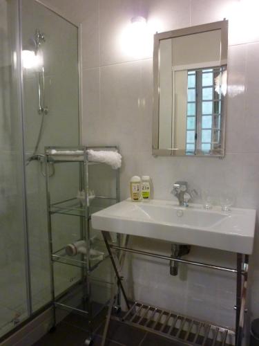une salle de bain avec un lavabo et une douche dans l'établissement L'Invitation au Voyage, à Bordeaux