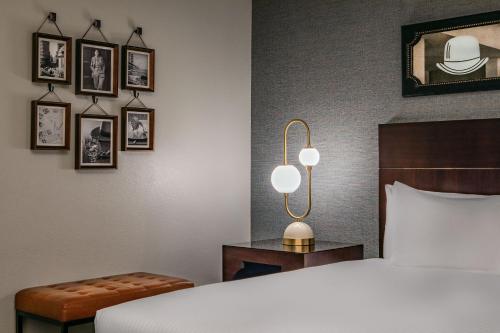 a bedroom with a bed and a lamp and pictures on the wall at Hotel Adagio, Autograph Collection in San Francisco