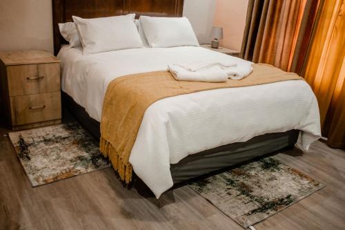 a bedroom with a bed with two towels on it at Cozy Livin - Duplex in Maseru