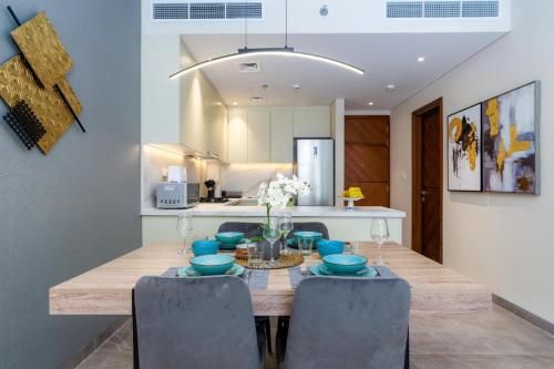 a dining room with a wooden table and chairs at White Sage New Large 1BR at JVC in Dubai