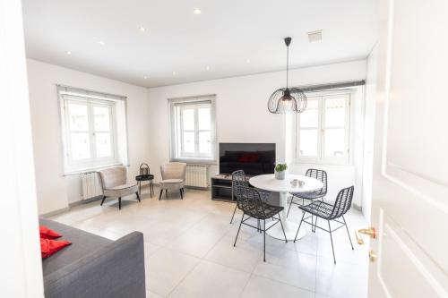 a living room with a table and chairs at Piazza Unità House in Trieste