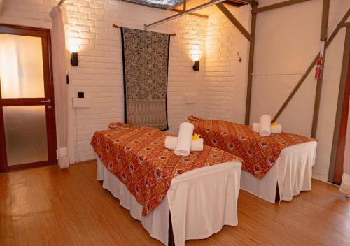 a room with two beds and a mirror at The ANMON Resort Bintan in Lagoi