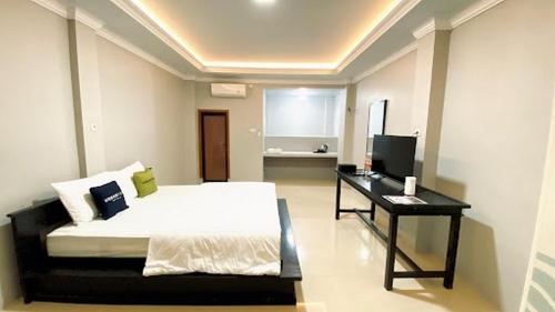 a bedroom with a bed and a desk in it at Urbanview TWH Costel near Stadion Maguwoharjo Yogyakarta in Yogyakarta