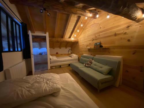 una camera con divano e un letto in una cabina di Chalet au cœur de la montagne a Valmeinier